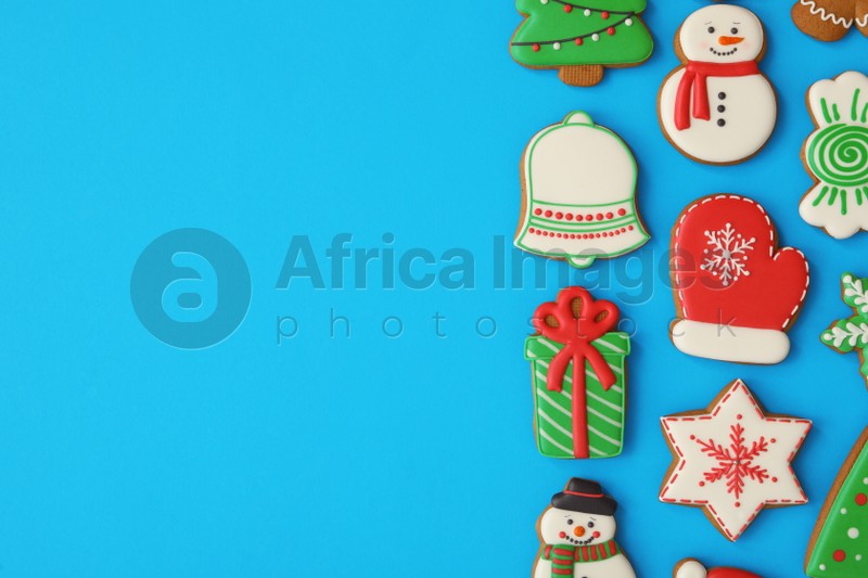 Different Christmas gingerbread cookies on light blue background, flat lay. Space for text