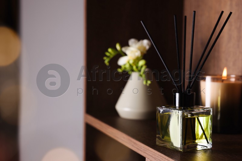 Aromatic reed air freshener on wooden shelf, space for text