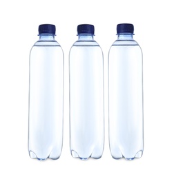 Plastic bottles with water on table against white background