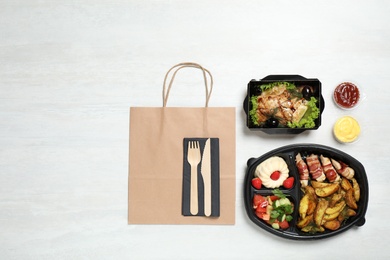 Flat lay composition with lunchboxes on white table. Healthy food delivery