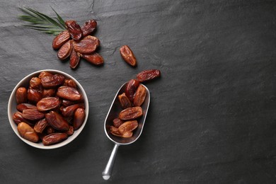 Flat lay composition with tasty sweet dried dates on black table. Space for text