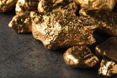 Pile of gold nuggets on grey table, closeup