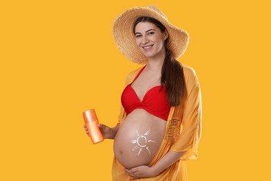 Photo of Young pregnant woman with sun protection spray on yellow background. space for text