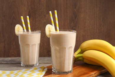 Glasses with banana smoothie on wooden table