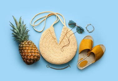 Flat lay composition with woman's straw bag on light blue background