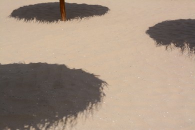 Shadows from umbrellas on sandy beach. Tropical resort