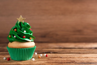 Christmas tree shaped cupcake on wooden table. Space for text