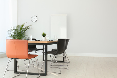 Simple office interior with large table and chairs