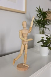 Photo of Stylish wooden figurine near houseplants on white table indoors