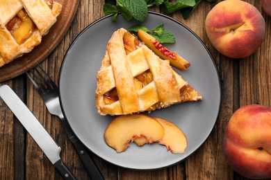 Delicious fresh peach pie served on wooden table, flat lay