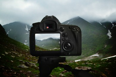 Taking photo of beautiful mountain landscape with camera mounted on tripod
