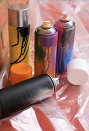 Used cans of spray paints on table near brick wall. Graffiti supplies