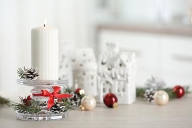 Christmas composition with glass candlestick on table in room. Space for text