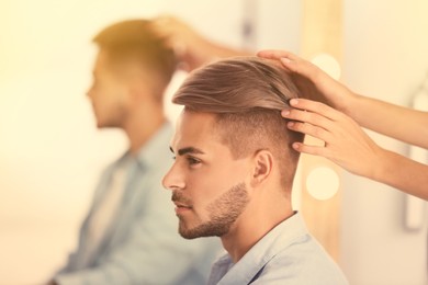 Image of Professional hairdresser working with young man in barbershop