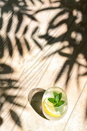 Refreshing water with lemon and mint on wooden table, space for text