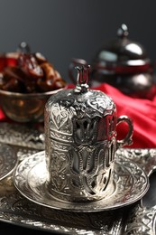 Photo of Tea and date fruits served in vintage tea set on table, closeup