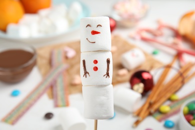 Funny snowman made of marshmallows on blurred background, closeup