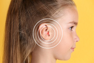 Cute little girl with hearing problem on yellow background, closeup