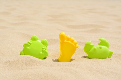 Colorful plastic molds on sand, space for text. Beach toys