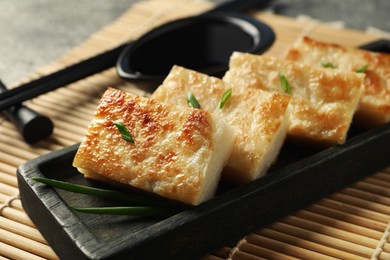 Delicious turnip cake with green onion on 'mat, closeup