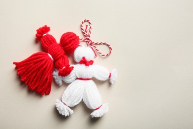 Traditional martisor shaped as man and woman on light background, top view with space for text. Beginning of spring celebration