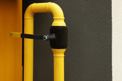 Photo of Yellow gas pipe near brown wall outdoors