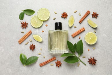 Photo of Flat lay composition with bottle of perfume, lime and spices on light grey background