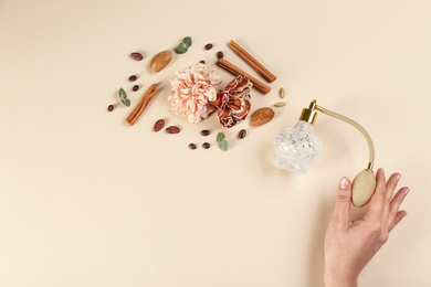 Woman with perfume. Fragrance composition, flowers and cinnamon on beige background,  top view