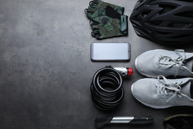 Flat lay composition with different cycling accessories on grey background, space for text