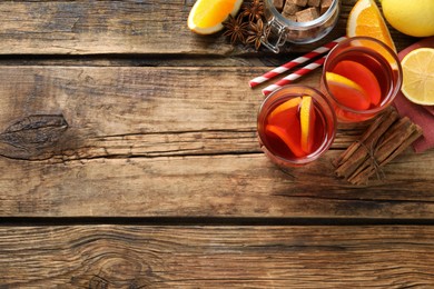 Aromatic punch drink and ingredients on wooden table, flat lay. Space for text