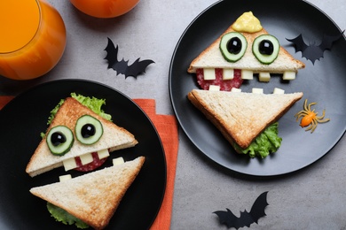 Cute monster sandwiches served on grey table, flat lay . Halloween party food