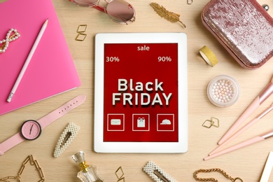 Flat lay composition with tablet and stylish accessories on wooden background. Black Friday sale