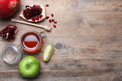 Honey, pomegranate and apples on wooden table, flat lay with space for text. Rosh Hashana holiday