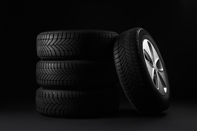 Set of wheels with winter tires on black background