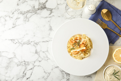 Photo of Delicious pasta with shrimps served on white marble table, flat lay. Space for text