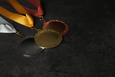 Gold, silver and bronze medals on grey stone background. Space for design