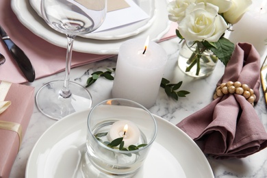 Elegant festive table setting on white marble background, closeup