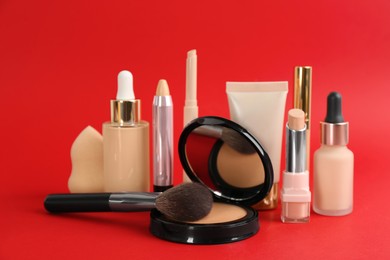 Foundation makeup products on red background. Decorative cosmetics