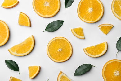 Fresh orange slices and leaves on white background, top view
