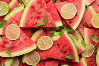 Slices of juicy watermelon with lime and mint as background, top view