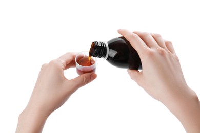 Woman pouring syrup into measuring cup from bottle isolated on white, closeup. Cough and cold medicine