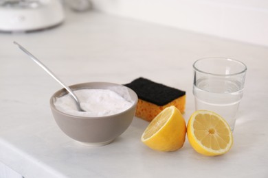 Photo of Baking soda, lemon, vinegar and sponge on counter. Natural detergent