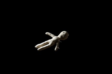 Voodoo doll with pins on black background