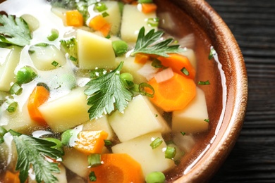 Bowl of fresh homemade vegetable soup on table, closeup