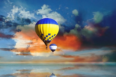 Fantastic dreams. Hot air balloons in blue sky with clouds over sea
