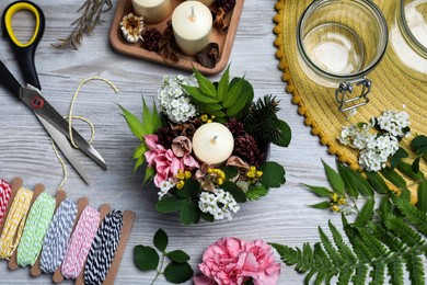 Beautiful floral composition and different handicraft equipment on white wooden table, flat lay. Master class in handmade craft