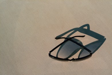 Stylish sunglasses on grey surface, top view with space for text. Beach accessory
