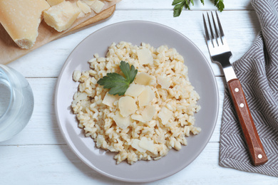 Photo of Delicious risotto with cheese on white wooden table, flat lay
