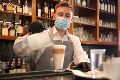 Barista preparing coffee at counter in restaurant. Catering during coronavirus quarantine
