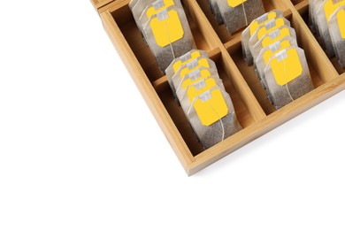 Paper tea bags with tags in wooden box on white background, above view